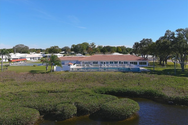 rear view of house with a yard and a water view