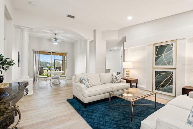 living room featuring ceiling fan, light wood-type flooring, and decorative columns