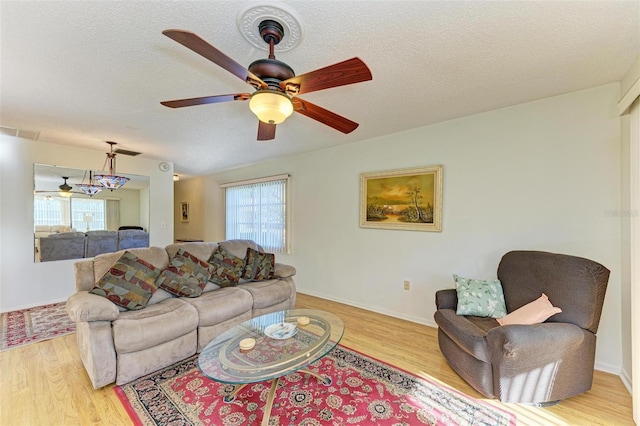 living room featuring ceiling fan, plenty of natural light, and light wood-type flooring