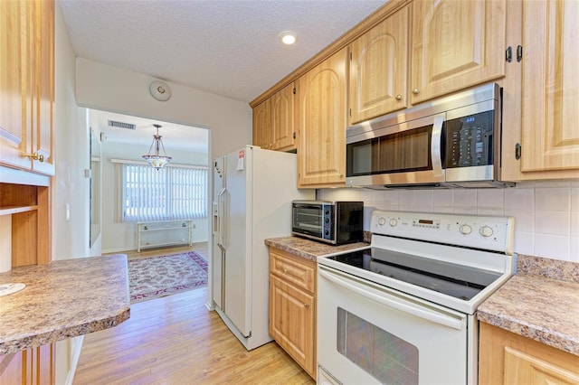 kitchen featuring tasteful backsplash, a textured ceiling, white appliances, decorative light fixtures, and light hardwood / wood-style flooring