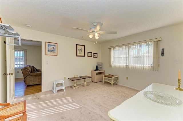 carpeted bedroom with ceiling fan and a textured ceiling