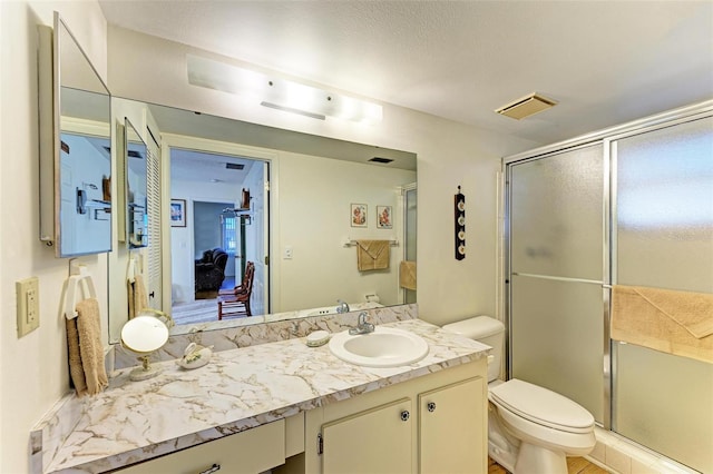 bathroom with vanity, toilet, and a shower with shower door