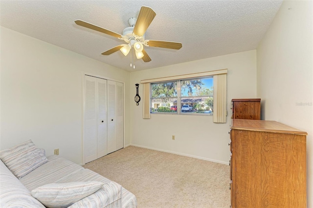 carpeted bedroom featuring ceiling fan, a closet, and a textured ceiling