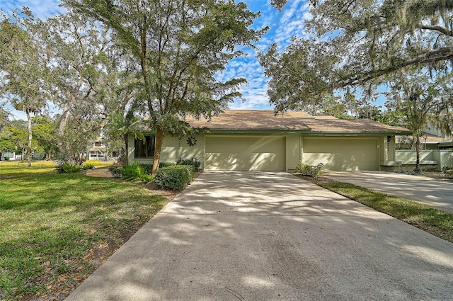 view of front of home featuring stucco siding, an attached garage, concrete driveway, and a front lawn