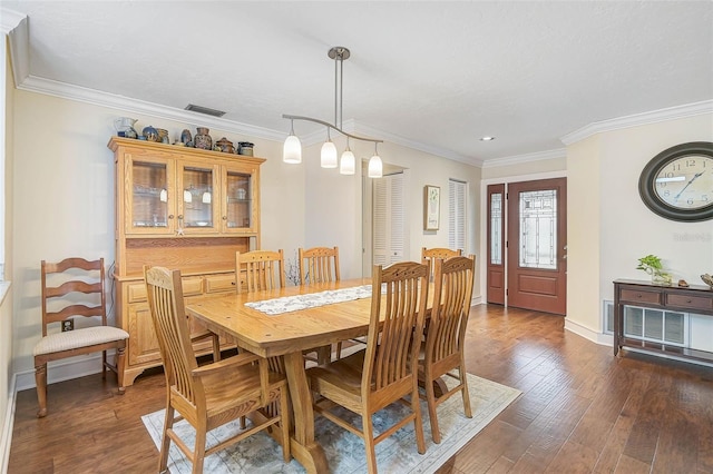 dining space with dark wood-type flooring and crown molding