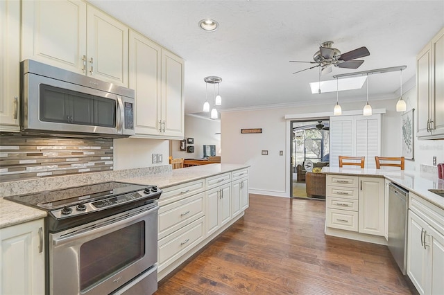 kitchen with kitchen peninsula, appliances with stainless steel finishes, crown molding, pendant lighting, and dark hardwood / wood-style floors