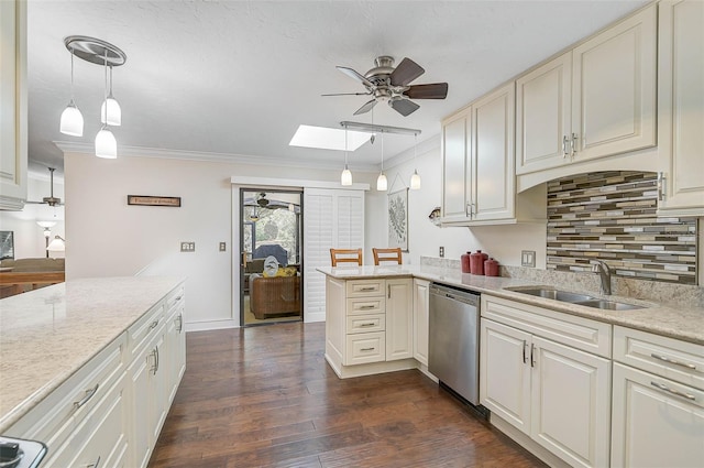 kitchen featuring a skylight, sink, stainless steel dishwasher, kitchen peninsula, and pendant lighting