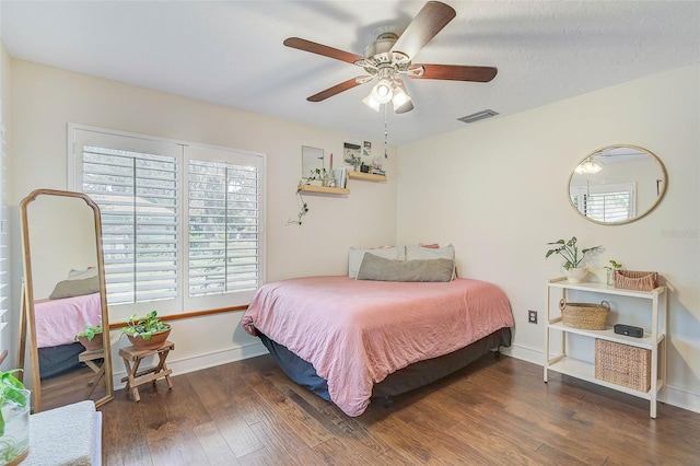 bedroom with ceiling fan and dark hardwood / wood-style floors