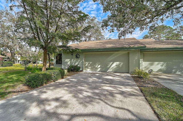 view of front facade with a garage, driveway, and stucco siding