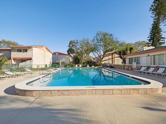 pool with a patio and fence