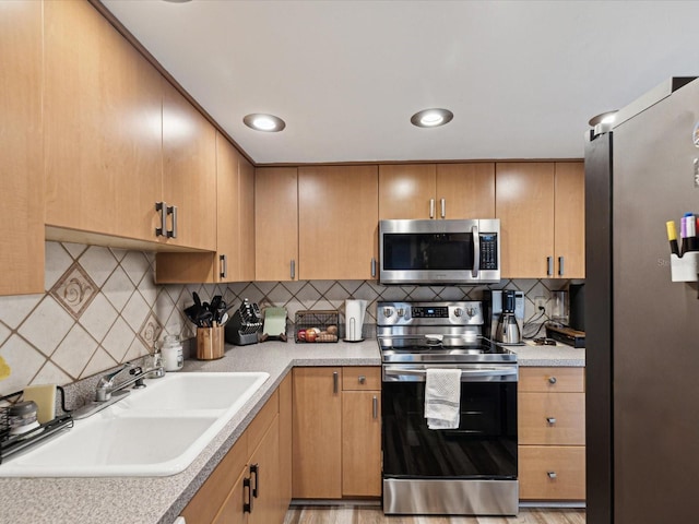 kitchen with a sink, light countertops, decorative backsplash, and stainless steel appliances