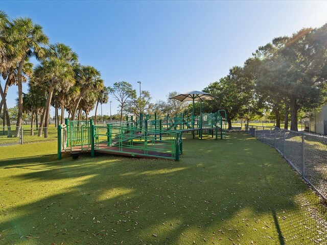 view of community with playground community, a yard, and fence