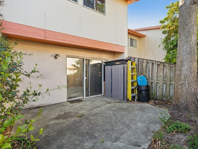 back of house featuring stucco siding, a patio, and fence