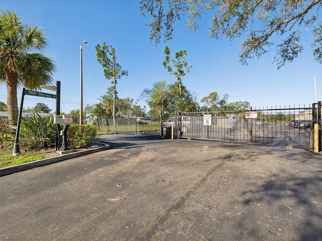 view of street with street lights, a gate, and a gated entry