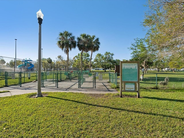 surrounding community with a gate, a lawn, and fence