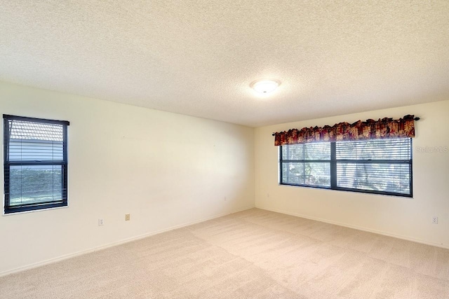 carpeted empty room featuring a textured ceiling