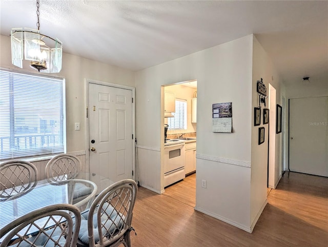dining space with a notable chandelier and light wood-type flooring