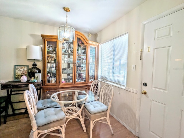 dining room with a wainscoted wall, wood finished floors, and wood walls