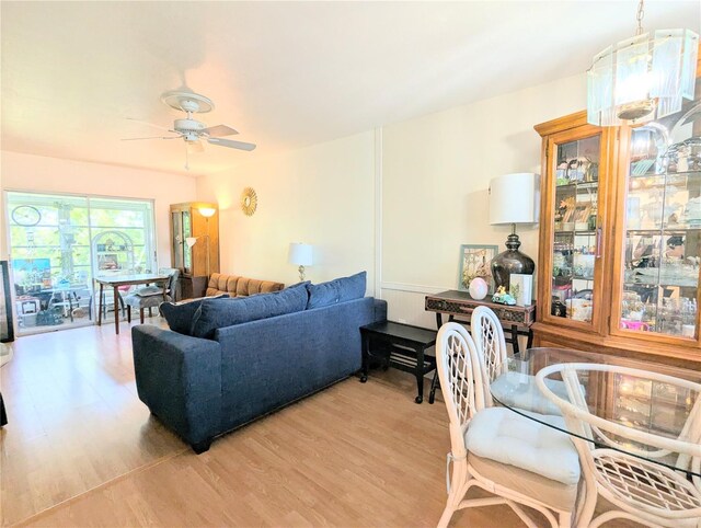 living room featuring a ceiling fan and light wood finished floors