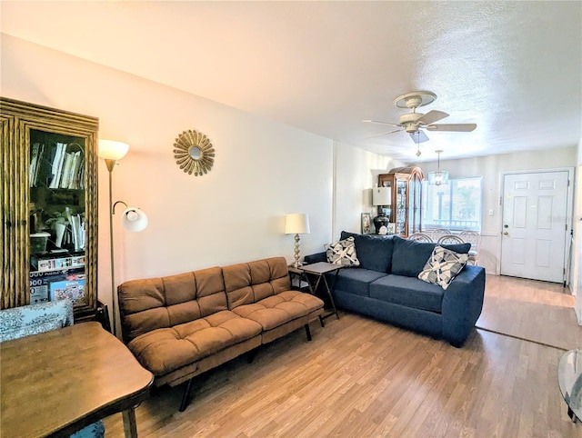 living area featuring light wood-style floors and ceiling fan