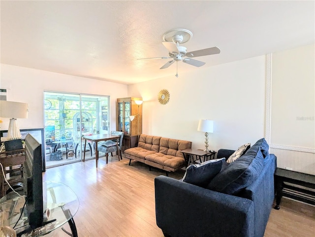 living area with light wood-type flooring and ceiling fan
