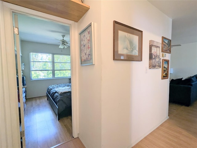 corridor with baseboards and wood finished floors