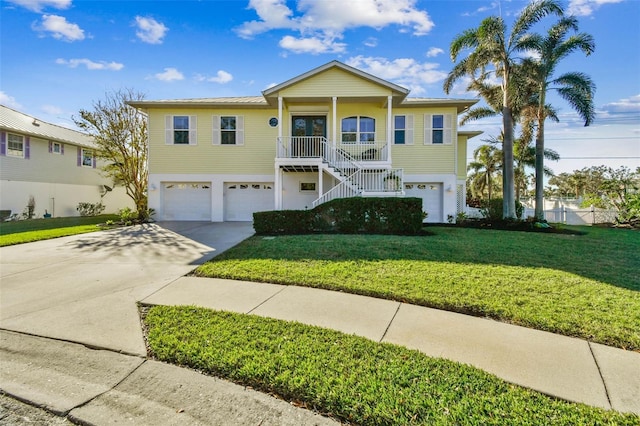 view of front of property featuring a garage, a porch, and a front yard