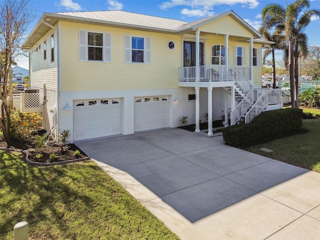 view of front facade featuring a porch, a garage, and a front lawn