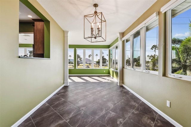 unfurnished sunroom with an inviting chandelier