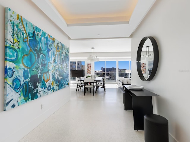 dining area with a tray ceiling and speckled floor