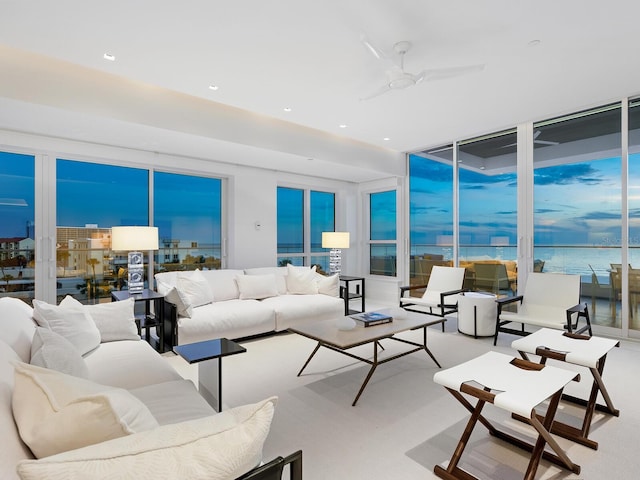 living room featuring a water view, floor to ceiling windows, a ceiling fan, and recessed lighting