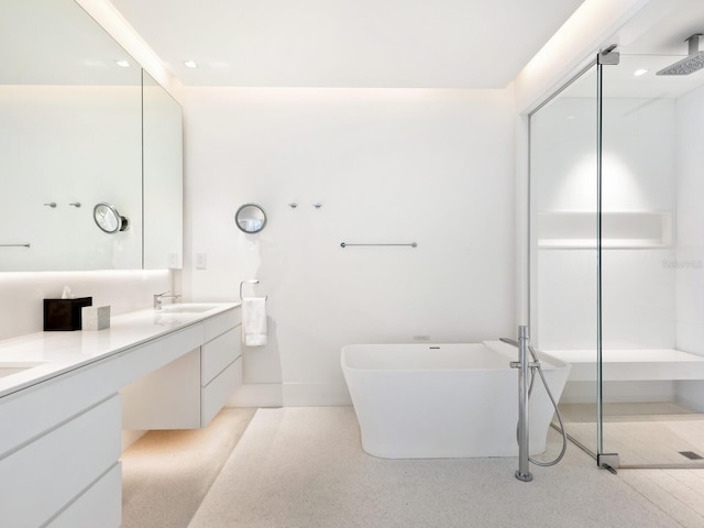 bathroom with a walk in shower, double vanity, a soaking tub, and a sink