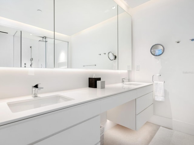 full bath with double vanity, a shower, and a sink