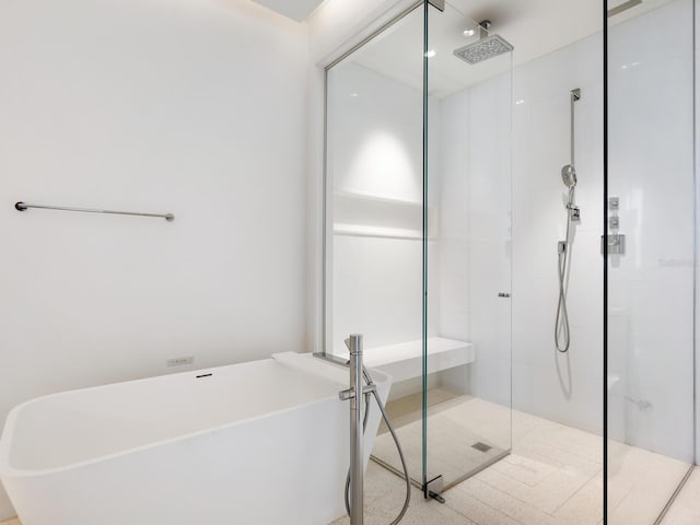 bathroom featuring a freestanding bath and a shower stall