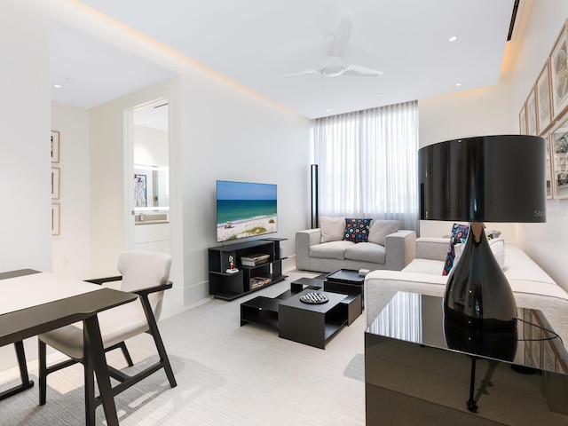 living area with ceiling fan and light carpet