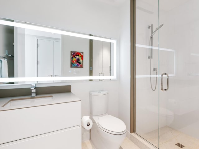 bathroom featuring vanity, a shower stall, and toilet