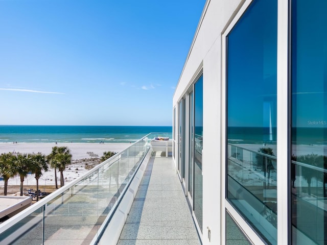 balcony with a water view and a beach view