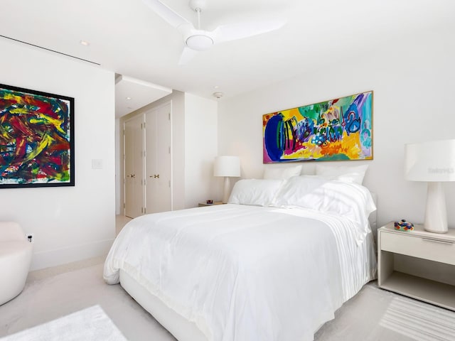 bedroom featuring a ceiling fan, light carpet, and baseboards