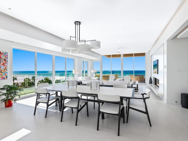 dining space featuring a water view and light speckled floor