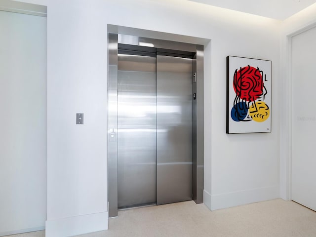 interior space featuring light colored carpet and elevator