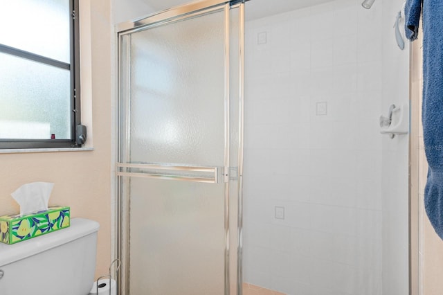 bathroom featuring toilet and an enclosed shower