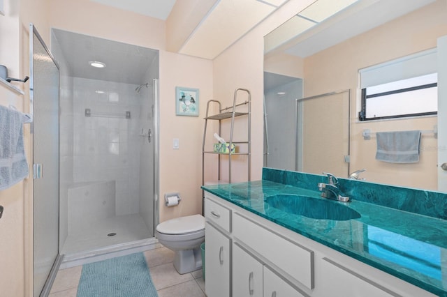 bathroom featuring tile patterned flooring, vanity, a shower with door, and toilet