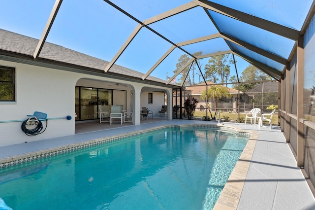 view of pool featuring a patio area, ceiling fan, and glass enclosure