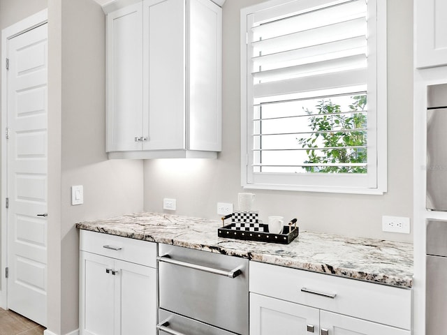 kitchen featuring white cabinetry and light stone countertops