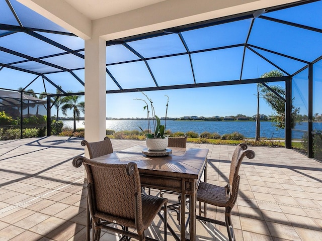 view of patio featuring a lanai and a water view