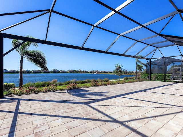 view of patio with glass enclosure and a water view