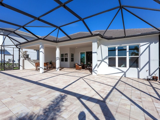 back of house featuring glass enclosure and a patio area