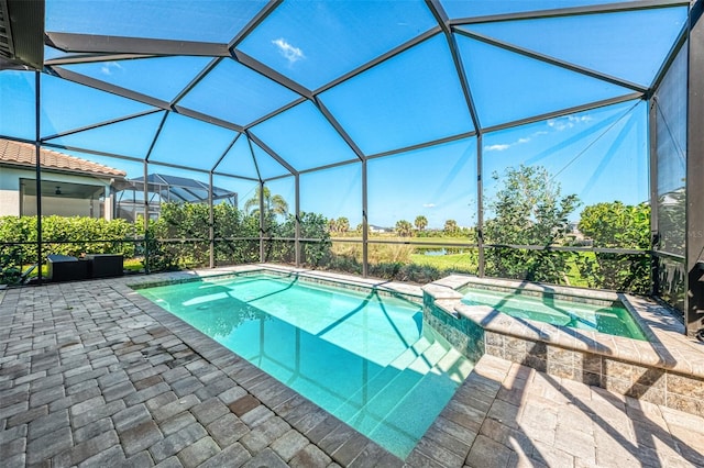 view of pool with a pool with connected hot tub, glass enclosure, and a patio