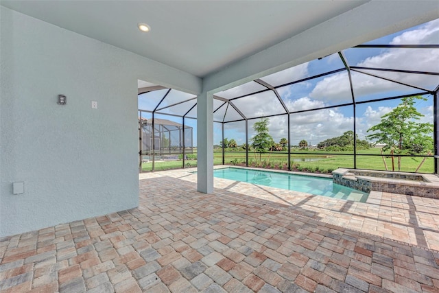 view of pool with a pool with connected hot tub, glass enclosure, and a patio