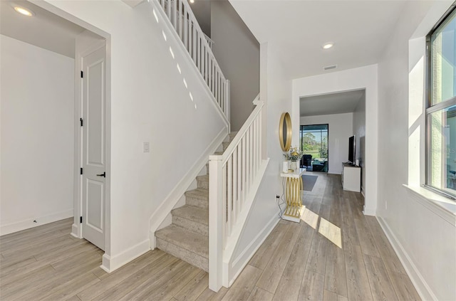 stairs with recessed lighting, wood finished floors, visible vents, and baseboards